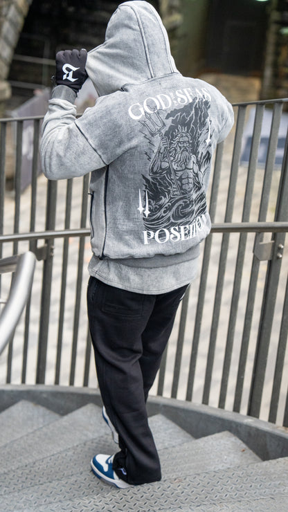 Person wearing a gray hoodie with a graphic design on the back, standing outdoors.